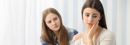 Young girl wants to help her sad friendの写真素材