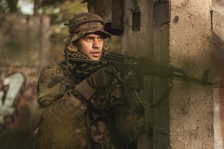 Armed young soldier participating in military manoeuvres