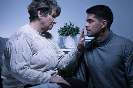 Photo of dying elderly woman having support of her grandsonの写真素材