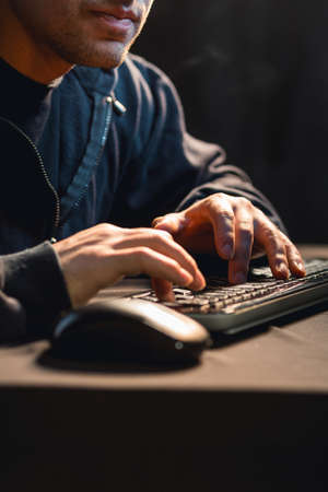 Close up of young man typing on computer keyboard