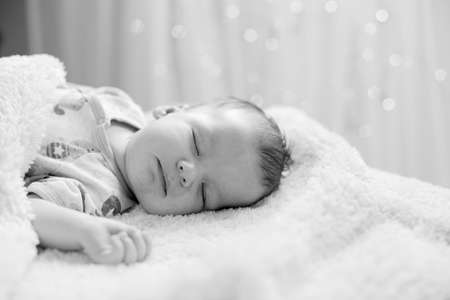 Black and white picture of newborn sleeping on backの写真素材