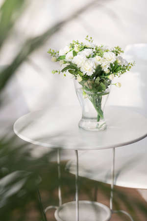 Beautiful delicate white flowers on the glass tableの写真素材