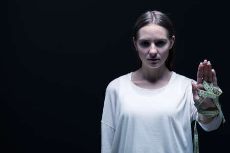 Image of bulimic girl in white  on black background