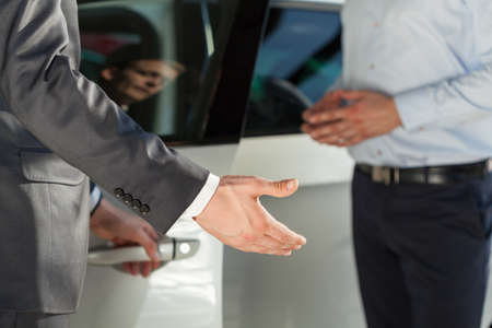 Car dealer is showing his customer new carの写真素材