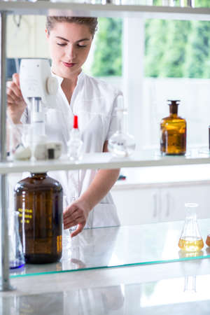 Young scientist is making a solution in a bottleの写真素材