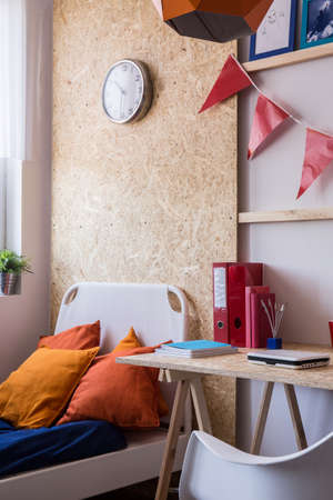 Photo of minimalist style wooden desk and white bed