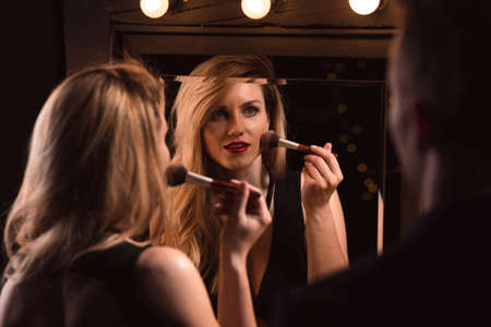 female lover doing make-up and her partnerの写真素材