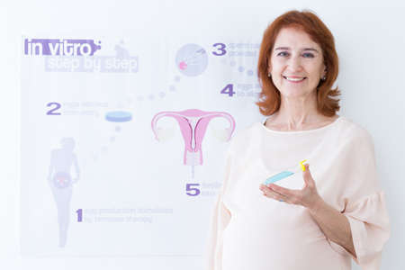 Happy older woman with test-tube and in vitro steps