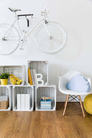 Wood, handmade furniture and bike hanging on wall in light room with flooringの写真素材