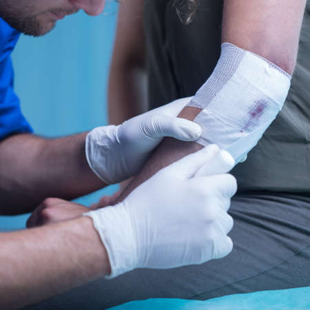 Close-up of male paramedic dressing elbow woundの写真素材
