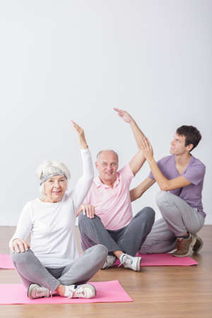 Active happy seniors on fitness classes with physiotherapist