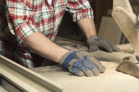 Close up of carpenter with safety gloves during work