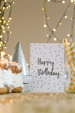 Birthday card lying on table with golden decorationの写真素材