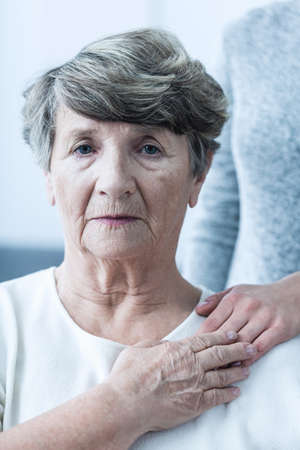 Despair senior woman supported by caring personの写真素材