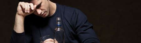 Picture of young broken man drinking alcoholの写真素材