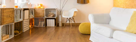 Spacious room with stylish decorations, modern chair and white double sofa