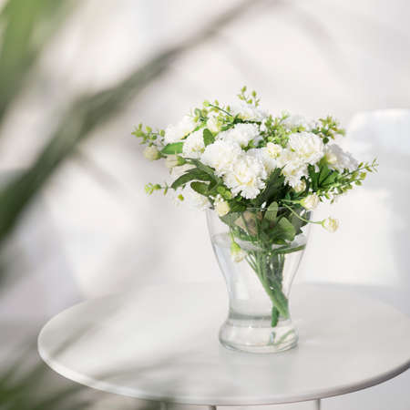 Beautiful delicate white flowers on the glass tableの写真素材
