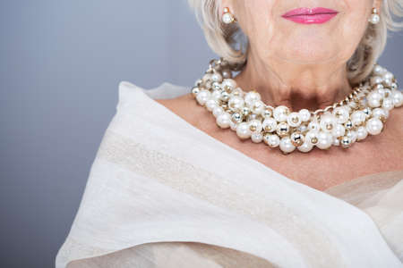 Rich, senior woman wearing elegant shawl and precious pearl jewelleryの写真素材