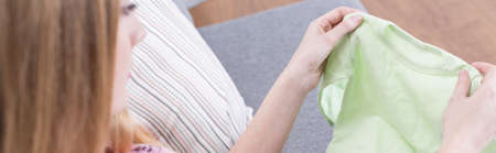 Young woman is preparing clothes for her babyの写真素材