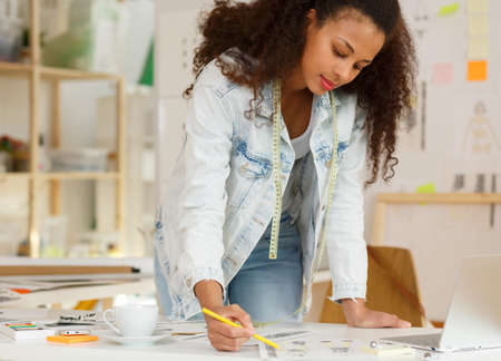 Shot of a young fashion designer improving some drawings