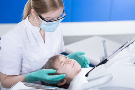 Picture of a scared little boy and his dentist in a clinicの写真素材