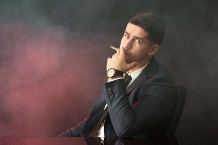 Busy evil businessman smoking cigarette for stressの写真素材