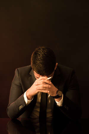 Broken down young businessman with cigarette