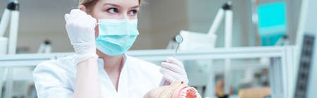 Young dentistry student with a mouth mirror in her hand