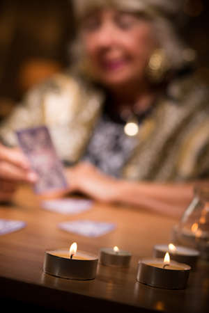 Close-up of fortune teller with candles on her tableの写真素材