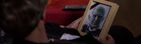 Woman is holding photograph of her passed husband