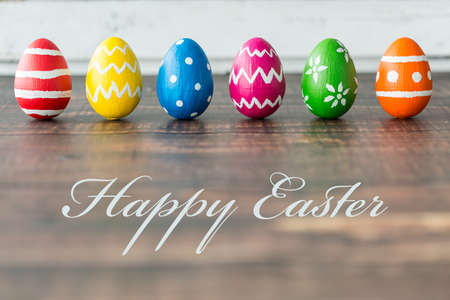 Beautiful decorative easter eggs lying on wood, brown table