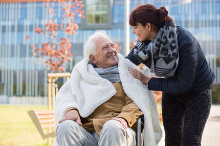 Photo of elderly man and his caring daughter