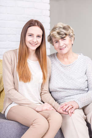 Shot of a young woman sitting on a couch with her grandmother