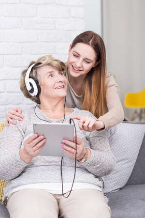 Shot of a young woman showing her grandma how to use a tabletの写真素材