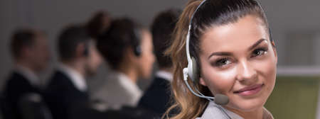 Young beautiful girl with headset working in call center office