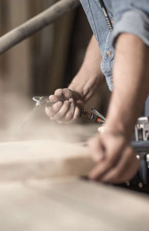 Young carpenter is using wood in his workの写真素材