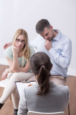 Female psychologist helping worried young coupleの写真素材