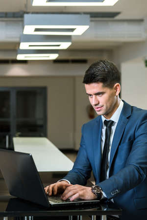 Elegant businessman in suit working on computer in modern office