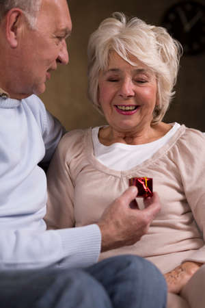 Shot of a senior man giving a present to his wife