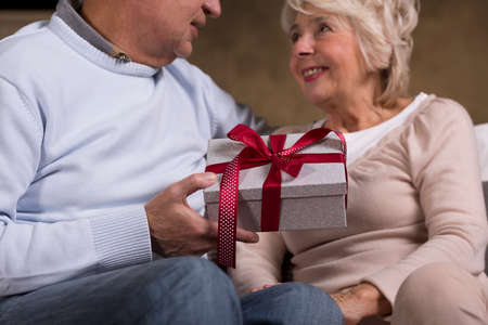 Shot of a senior man giving a present to his wifeの写真素材