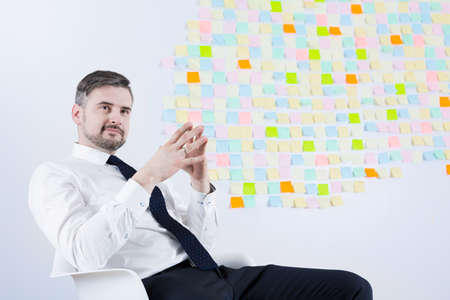 Middle aged handsome businessman running his own company. Sitting relaxed in chair in officeの写真素材