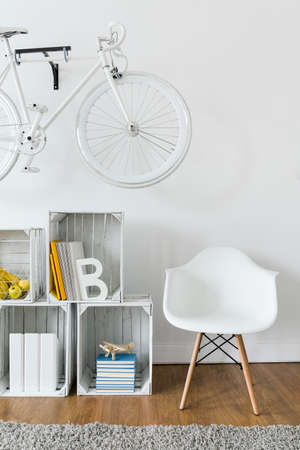 Close-up of cozy reading corner with wooden shelf and white armchair in modern loungeの写真素材