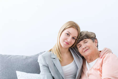 Photo of young granddaughter helping ill grandmotherの写真素材