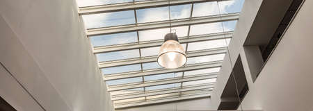 Close-up of little lamp hang by the ceiling in spacious college building
