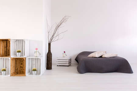 White, spacious bedroom with large bed, handmade nightstand and regaleの写真素材