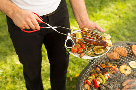Close-up of man serving delicious grilled mealの写真素材