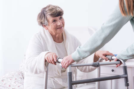 Photo of senior lady with walking zimmer and carerの写真素材