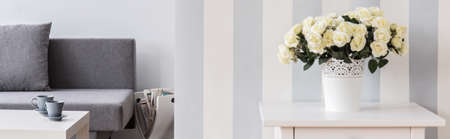 Fresh white roses in vase on night stand in cozy stylish living roomの写真素材