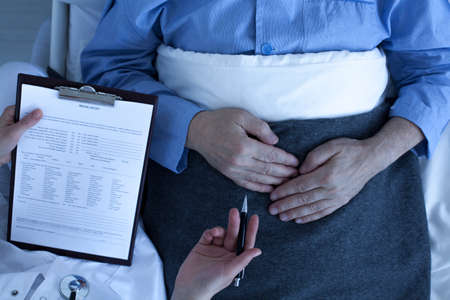 Cropped picture of a doctor holding a medcal history form and her patient laying on a bedの写真素材