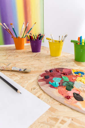 Shot of a desk with paints, crayons and brushesの写真素材